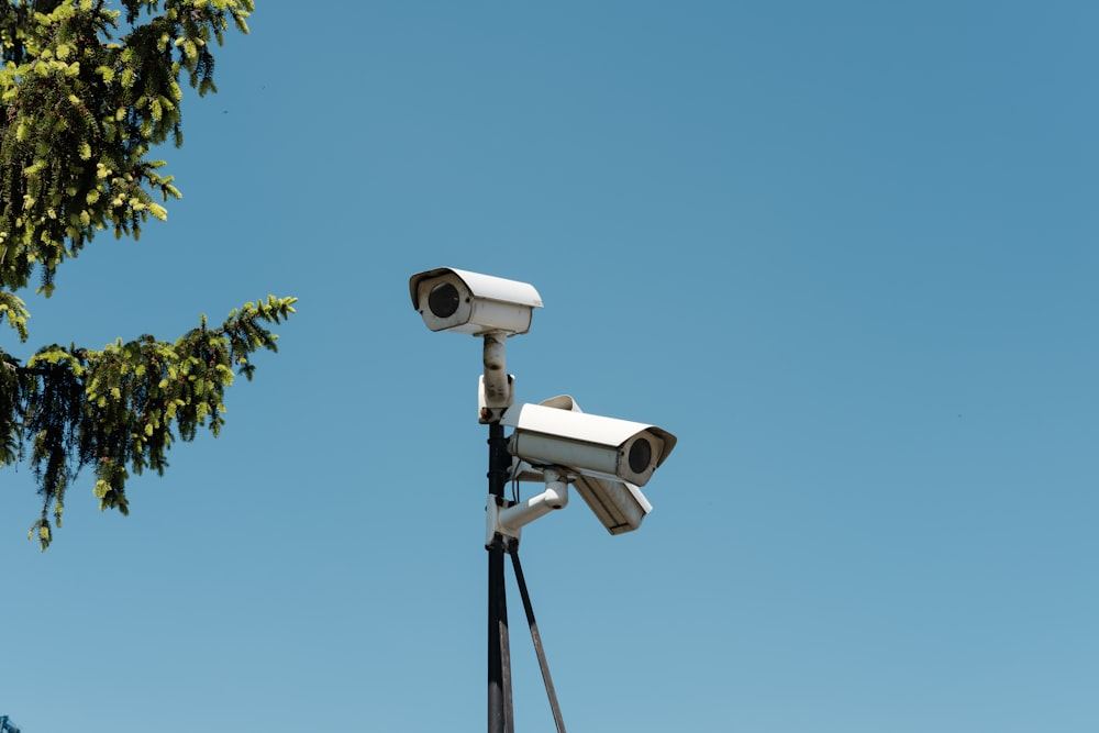 Pole mounted CCTV cameras against a clear sky